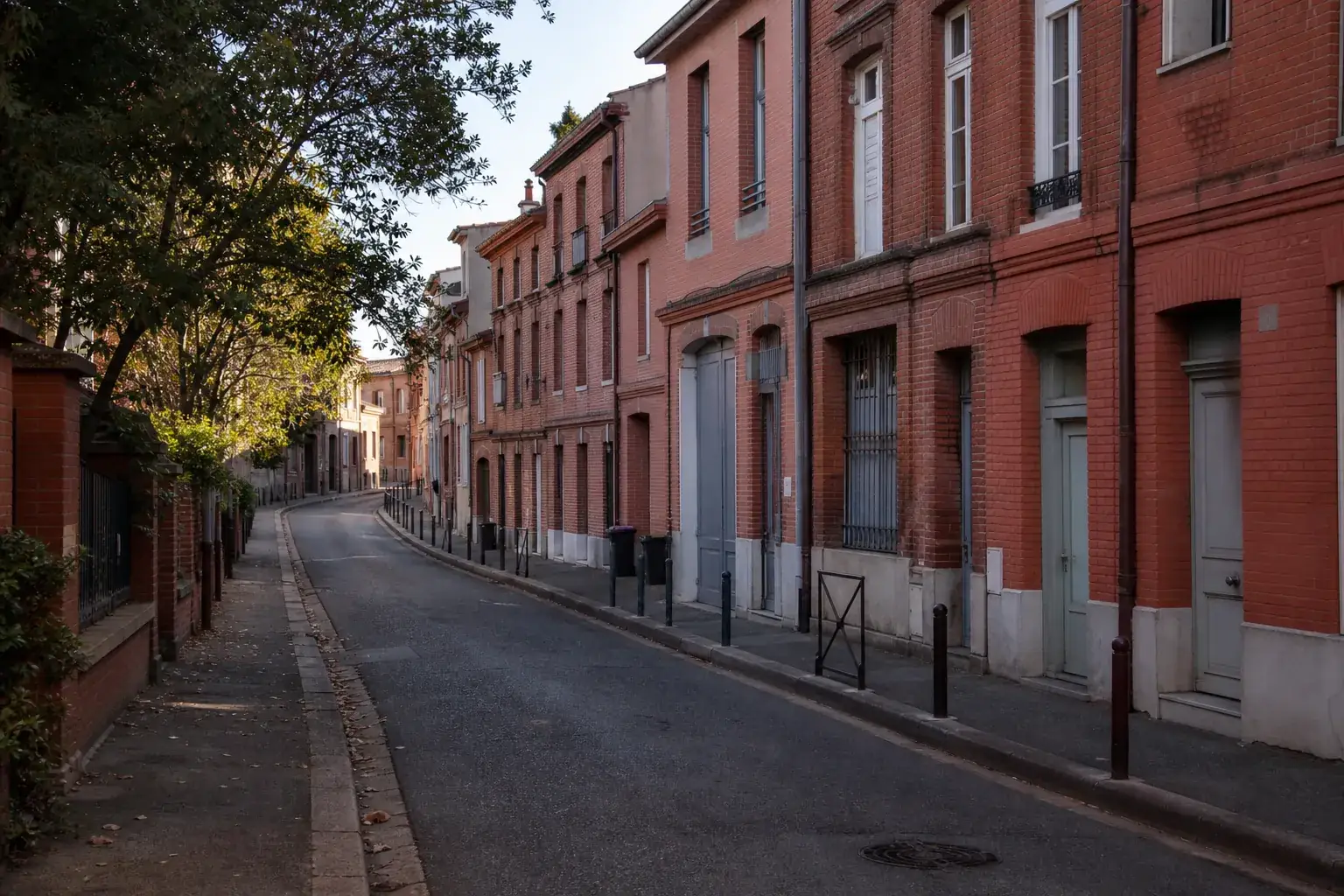Rue résidentielle toulousaine avec façades de brique et regards discrets